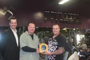 The AED being donated by Anytime Fitness's Noel Basilides to bar owner Michael Plunkett