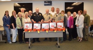 The Veterans Memorial Health Care Foundation gifted defibrillators to many local law enforcement officials last week following the successful community direct mail fund drive held last fall.  Each Allamakee County deputy as well as the Monona Police Department received a defibrillator for their vehicle to ensure CPR and defibrillation is quickly accessible in all sections of the Veterans Memorial Hospital service area.  Pictured, in front middle receiving the defibrillators are Brian Berger of the Monona Police Department; Clark Mellick, Allamakee County Sheriff, and Barry Olson, Allamakee County Deputy.  Also pictured, left to right are Veterans Memorial Health Care Foundation members Amy Cote’-Hill, Lori Bahr-Stevenson, Nona Sawyer, Craig Lensing, Gloria Krambeer, Wayne Burke, Jeff Mitchell, EMT-P, EMS Supervisor, Veterans Memorial Hospital, Jackie Halverson, Nancy Schoh, Jane Dietrich, Paula Kerndt Wickham, President of First Voice who supplied the defibrillators, and Dennis Lyons also of the Foundation.  